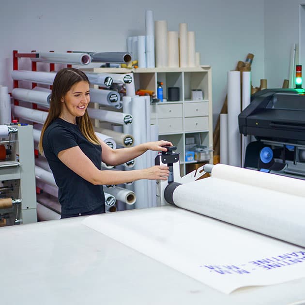 Medarbeider som arbeider med storformatmateriale i produksjonen