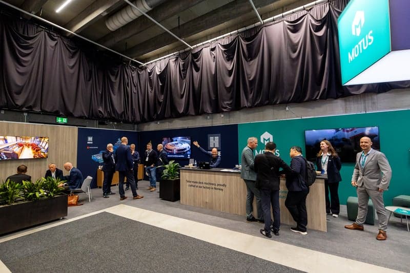 Profesjonell messestand med besøkende i samtale på en bransjekonferanse