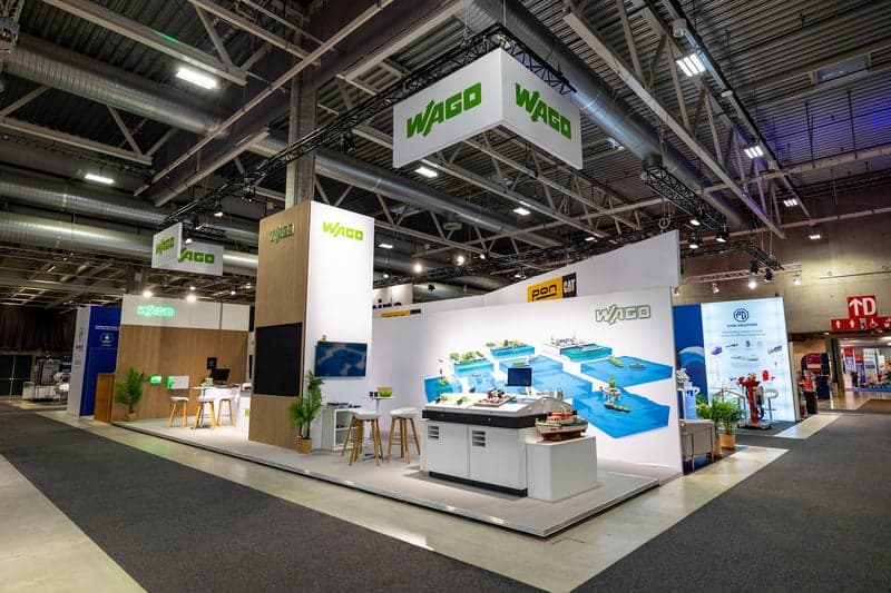 Large custom-designed trade show stand with hanging signage and interactive elements