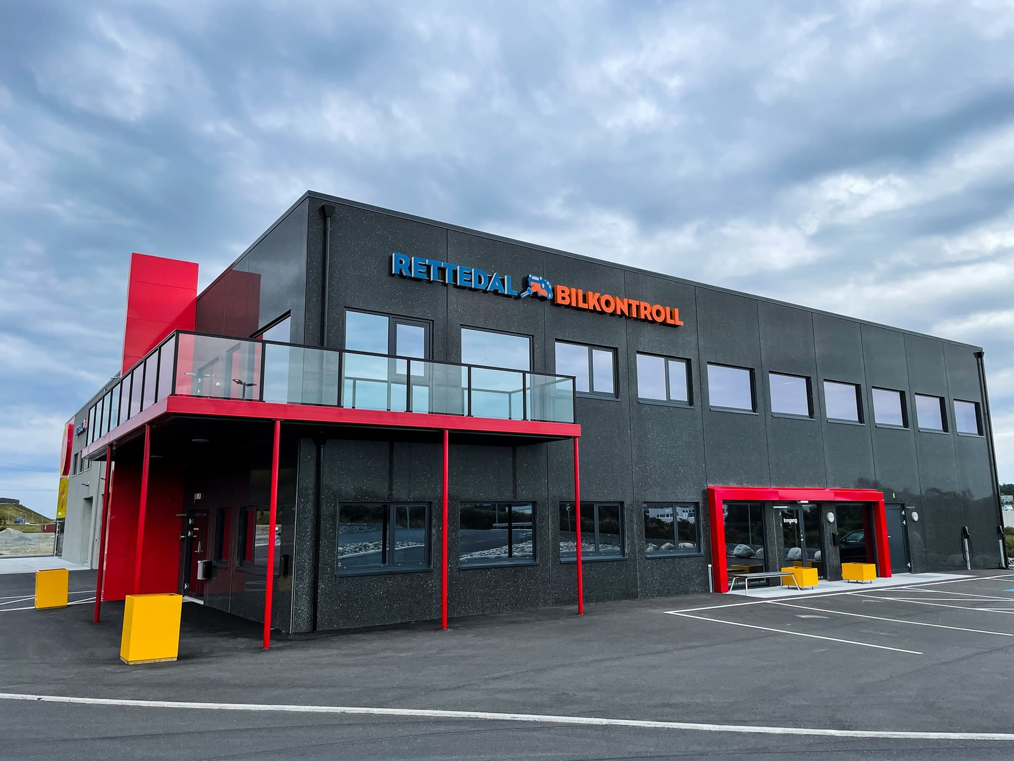 Facade sign for Rettedal Bilkontroll with 3D letters in orange and blue on dark facade in Rogaland