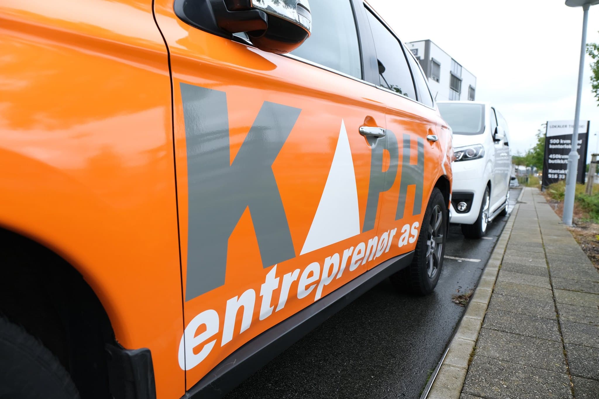 Detaljbilde av KAPH Entreprenør profilering på bil parkert utendørs