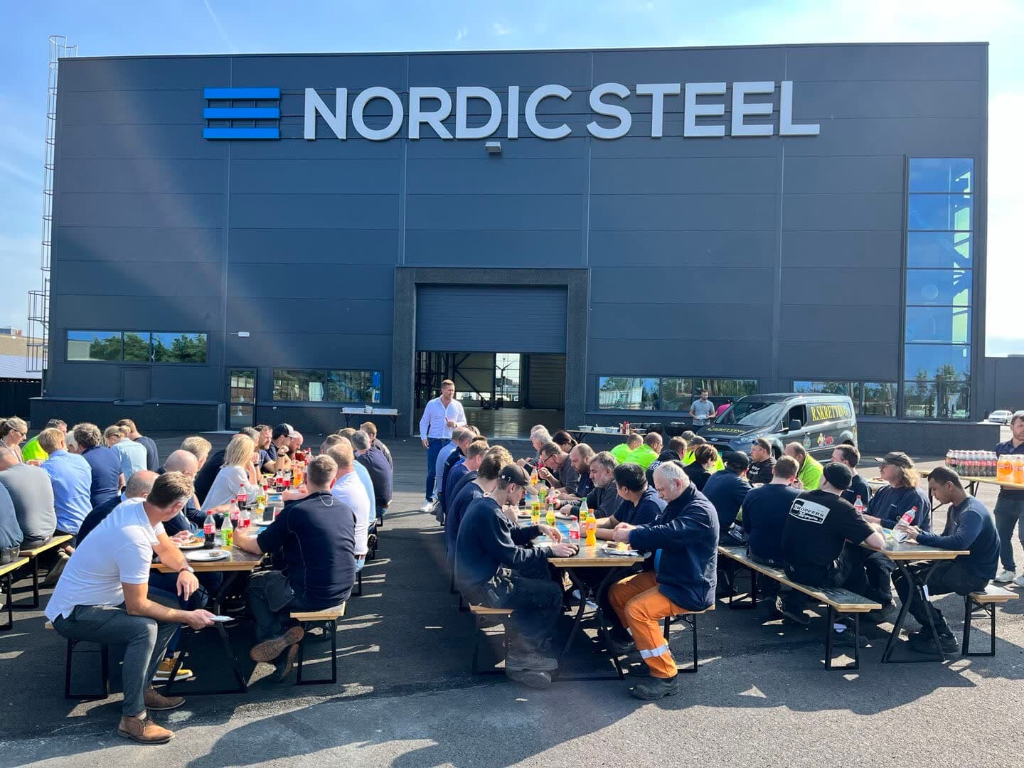 Nordic Steel-fasaden med det store skiltet og mennesker samlet utenfor bygget
