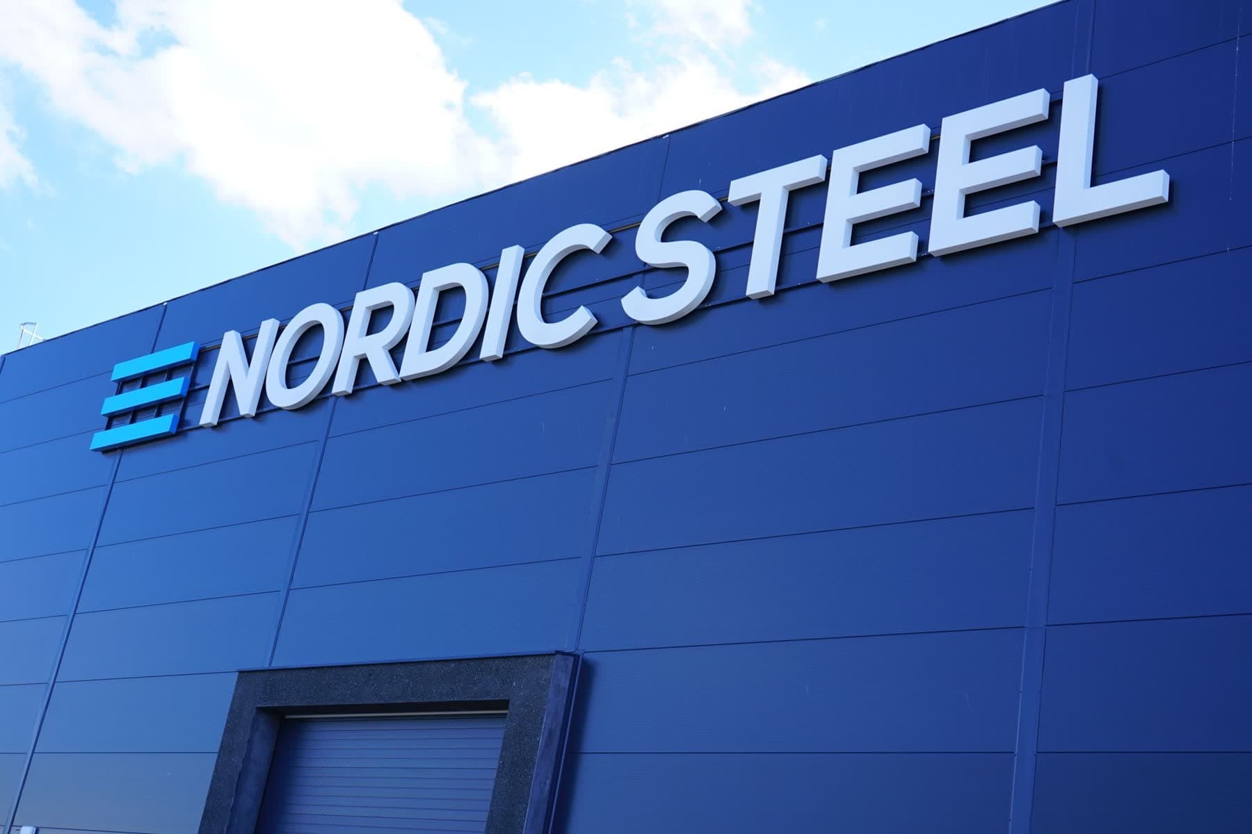 Detaljbilde av individuelle Nordic Steel-bokstaver montert på den mørke fasaden